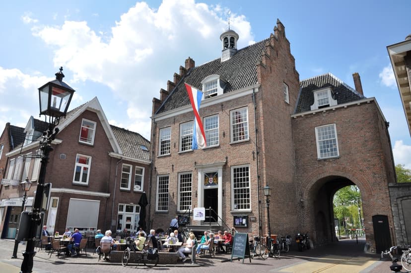 Het oude stadhuis en de IJsselpoort van Montfoort, met terras en vlag in de zon
