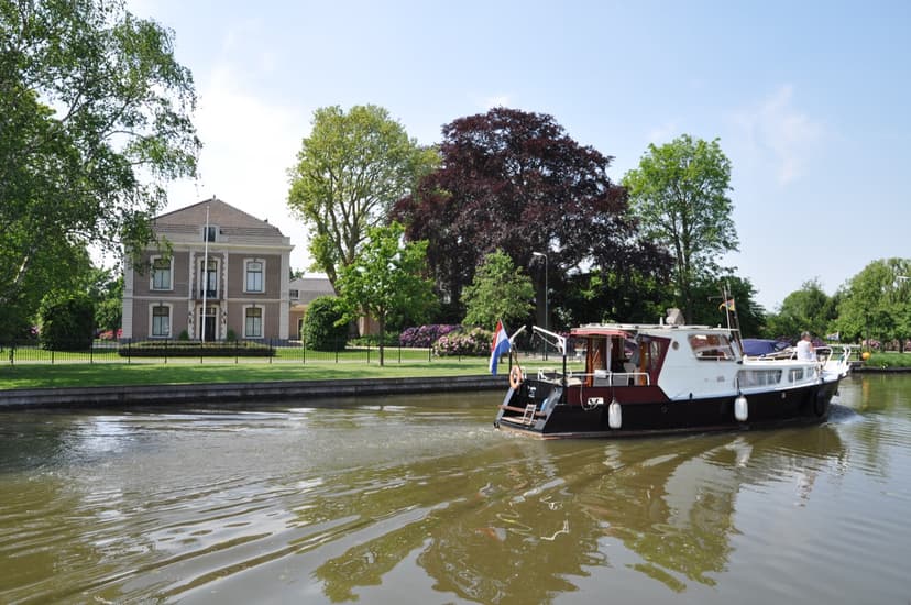Statig huis met tuin aan de Hollandse IJssel in Montfoort, met een bootje op het water