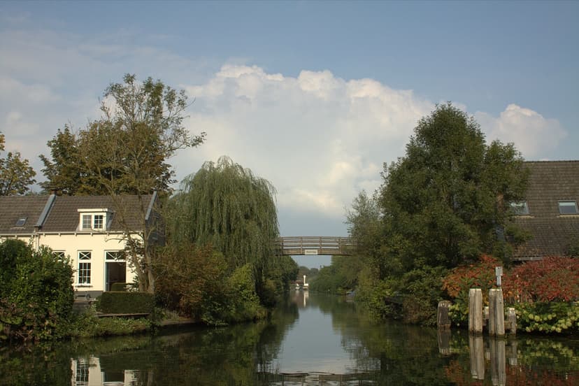 Huizen met tuinen aan het water van de Doorslag, met een houten fietsbruggetje