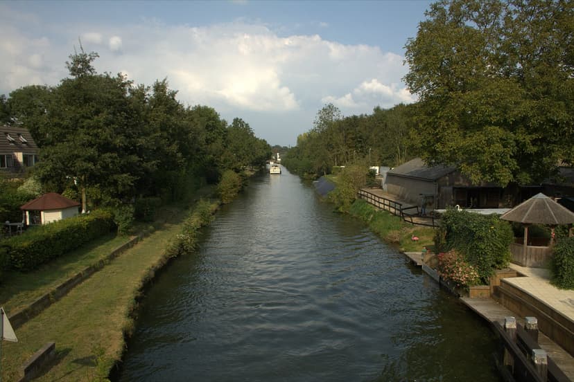 De Doorslag tussen bomen en tuinen, met een bootje in de verte