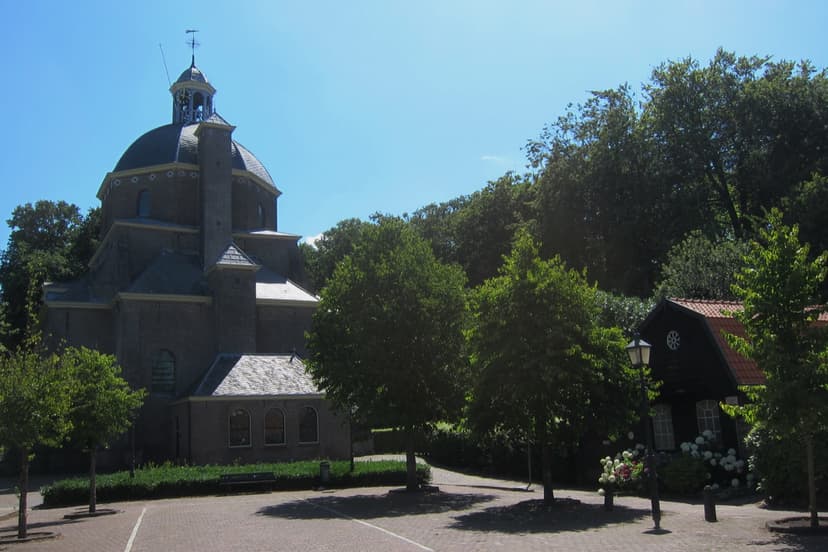 De Koepelkerk van Renswoude aan het pleintje in het dorp, tussen groene bomen