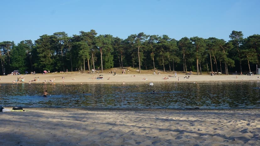 Zandstrand en zwemwater van het Henschotermeer op een zomerse dag