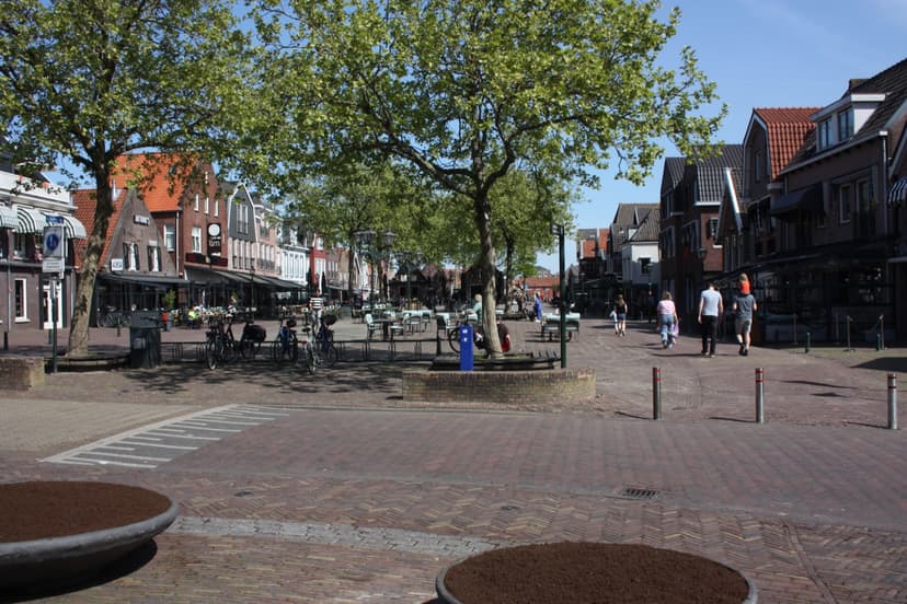 Het Spuiplein in Spakenburg met terrassen en winkels onder de bomen