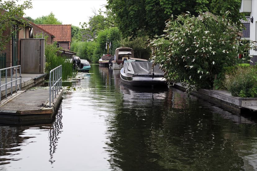 Smalle vaart met bootjes langs huizen en tuinen in Vinkeveen