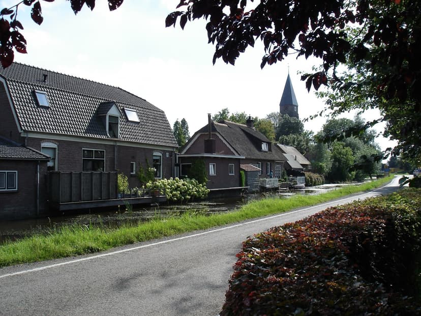Huizen aan het water in Cabauw met de toren van de Jacobuskerk