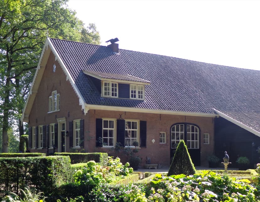 Oude langhuisboerderij met luiken en een verzorgde tuin in het buitengebied van Renswoude