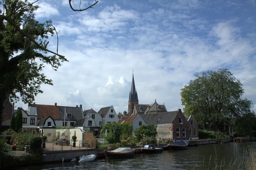 Huizen en tuinen aan de Vecht in Breukelen, met de kerktoren erboven