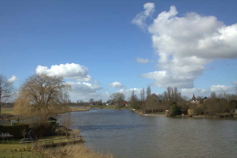 Kedichem aan de overkant van de Linge, met het kerktorentje tussen de bomen