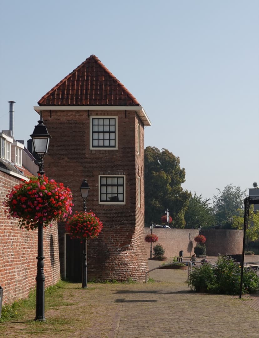 Oude toren in de stadsmuur van Leerdam, met bloembakken aan de lantaarnpalen