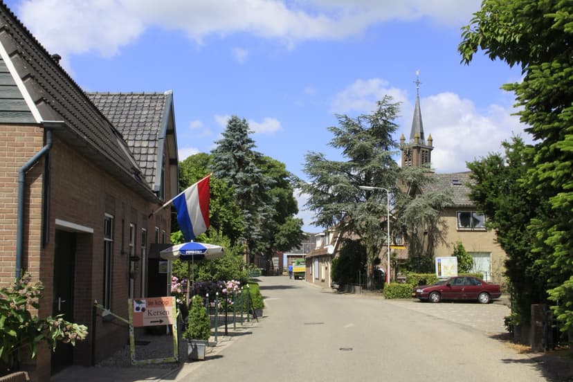 De Dorpsstraat in Zijderveld op een zomerdag, met de kerktoren tussen de bomen